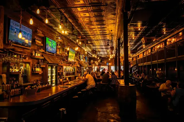 The main bar and dining hall under warm lights