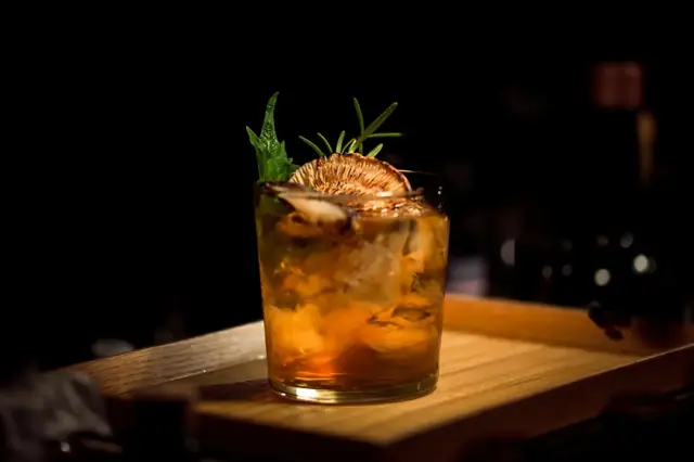 A house cocktail on the dark wood bar