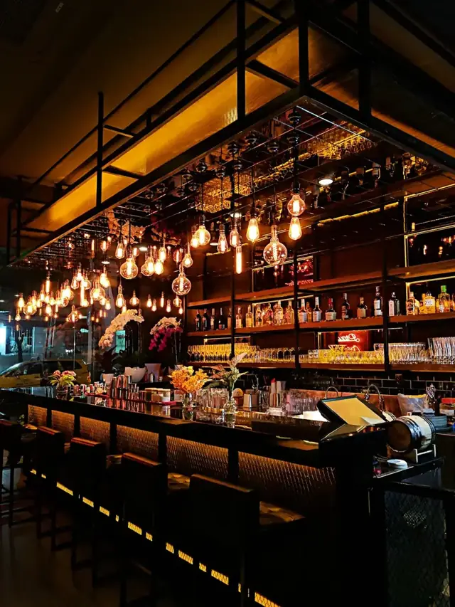 Tables under hanging bulbs by the bar